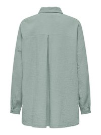 Chemise vert clair à manches longues, coupe ample, tissu texturé, empiècement dos et pli central au dos.