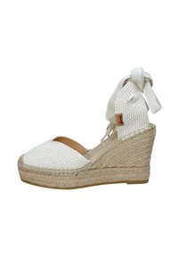 Sandalo con tacco wedge in espadrilles intrecciate bianche, con una parte superiore testurizzata, design con punta aperta e una cinghia alla caviglia in tessuto annodata. Base in juta.