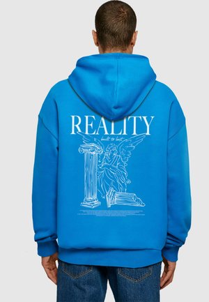 Felpa blu con una grande stampa grafica bianca che ritrae un angelo e colonne, con la scritta "REALITY built to last" sopra e dettagli intricati in linea.