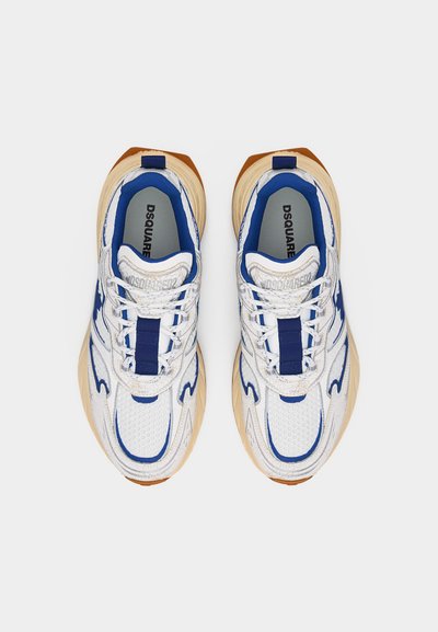 Baskets DSQUARED2 blanches et bleues avec semelles beige épaisses, vue de dessus montrant les lacets, le rembourrage intérieur et le nom de la marque sur les semelles intérieures.