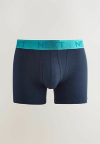 Tengerészkék boxer alsónadrág, puha, rugalmas anyagból készült. Széles türkiz kocsány jellemzi, amelyen a "NEXT" logó található, és támogató elülső zsebbe rendelkezik.