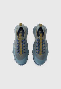 Blue athletic shoes with a mesh upper, textured rubber sole, and contrasting green laces. Features pull tabs for easy wear.