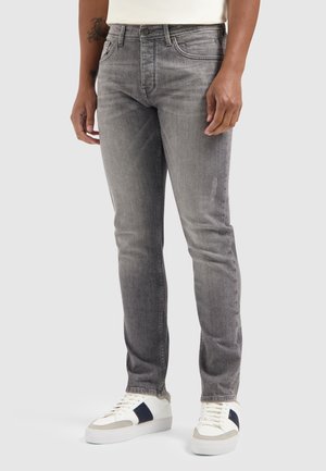 Gray denim jeans with a slim fit, featuring five pockets, subtle fading, and a classic button closure. Worn with white sneakers.