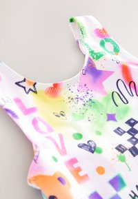 Kleurrijk badpak met een witte basis en roze, groene, oranje en paarse grafische ontwerpen, waaronder sterren en letters. Zachte stof.