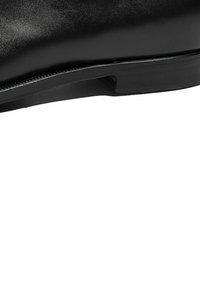 Zapato de cuero negro con un acabado suave, que presenta una forma elegante y una suela negra robusta con una sutil textura en el borde.