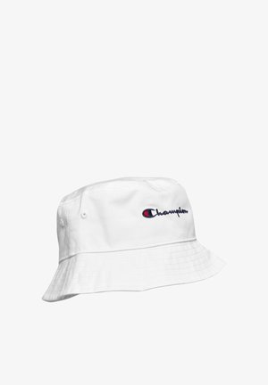 Witte katoenen vissershoed met gestikte rand en het Champion-logo in marineblauw en rood geborduurd aan de zijkant.