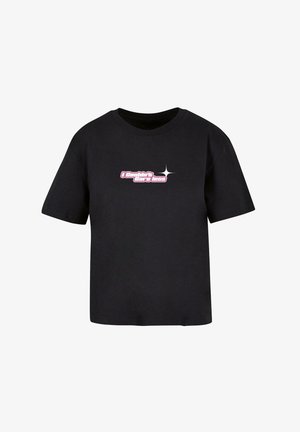 Must musta t-särk lühikeste varrukatega ja ümmarguse kaelusega. Ees on roosa tekst "Ma ei hooli vähem" koos tähe aksendiga.