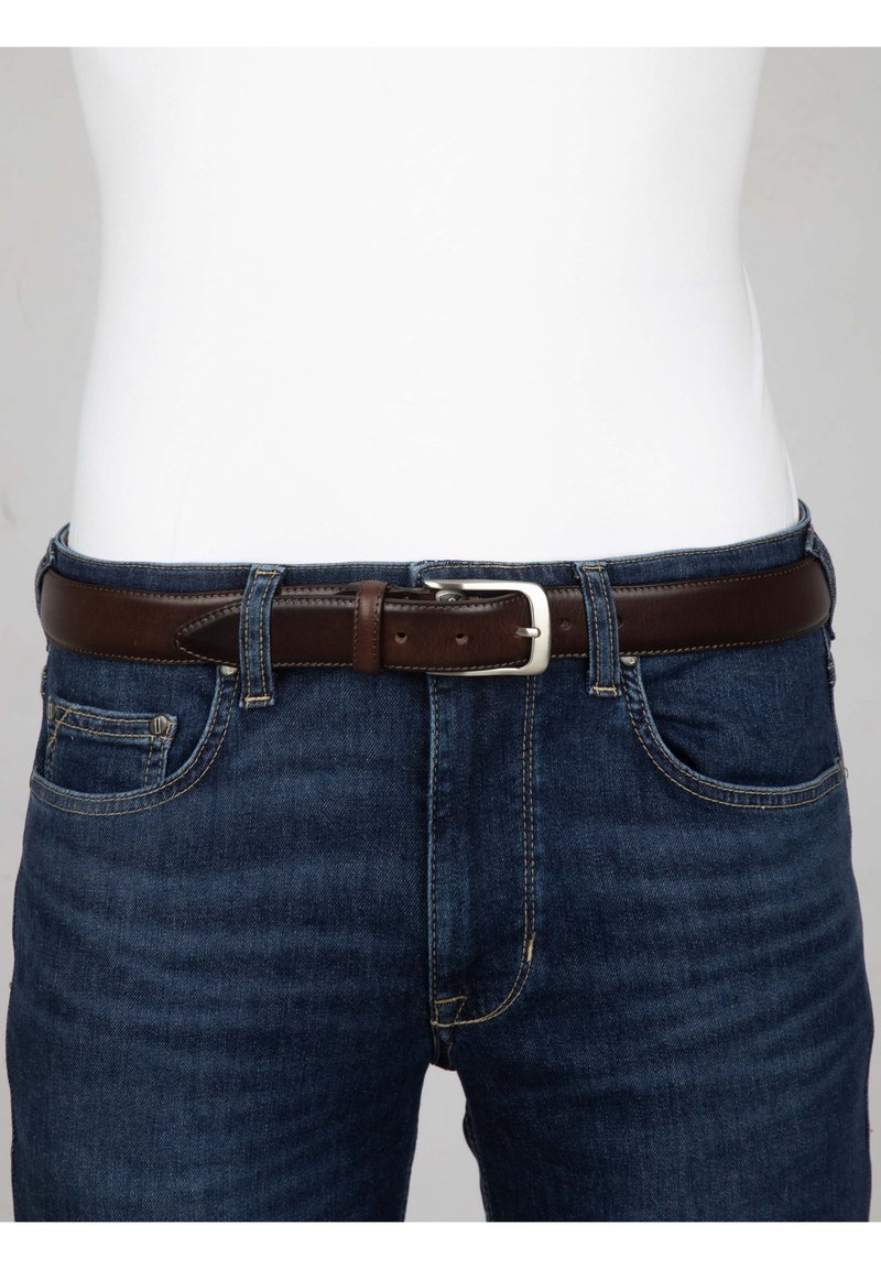 Bruine leren riem met een zilveren vierkante gesp, gedragen over donkerblauwe jeans. De riem heeft een gladde textuur en is door de riemlussen gehaald.