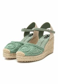 Espadrilles de cuña bordadas en verde con suela de yute natural, que cuentan con una delgada correa en el tobillo y acentos de tela beige en el talón.