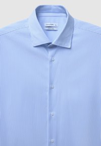 Hellblau gestreiftes Hemd in Slim Fit, aus pflegeleichtem Stoff. Verfügt über eine knöpfbare Vorderseite und einen klassischen Kragen mit glatter Textur.