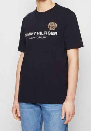 Granatowa bawełniana koszulka z okrągłym dekoltem, z dużym białym logo oraz napisem "TOMMY HILFIGER NEW YORK, NY" oraz małym logo na rękawie.
