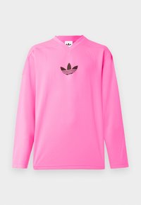 Långärmad rosa mesh-sporttröja med V-hals och en svart logotypdetalj på bröstet. Slät textur med en avslappnad passform.