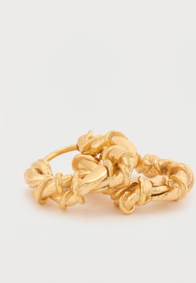 Brincos de argola dourados com um design torcido e detalhes texturizados. A superfície apresenta um acabamento polido com variações subtis.