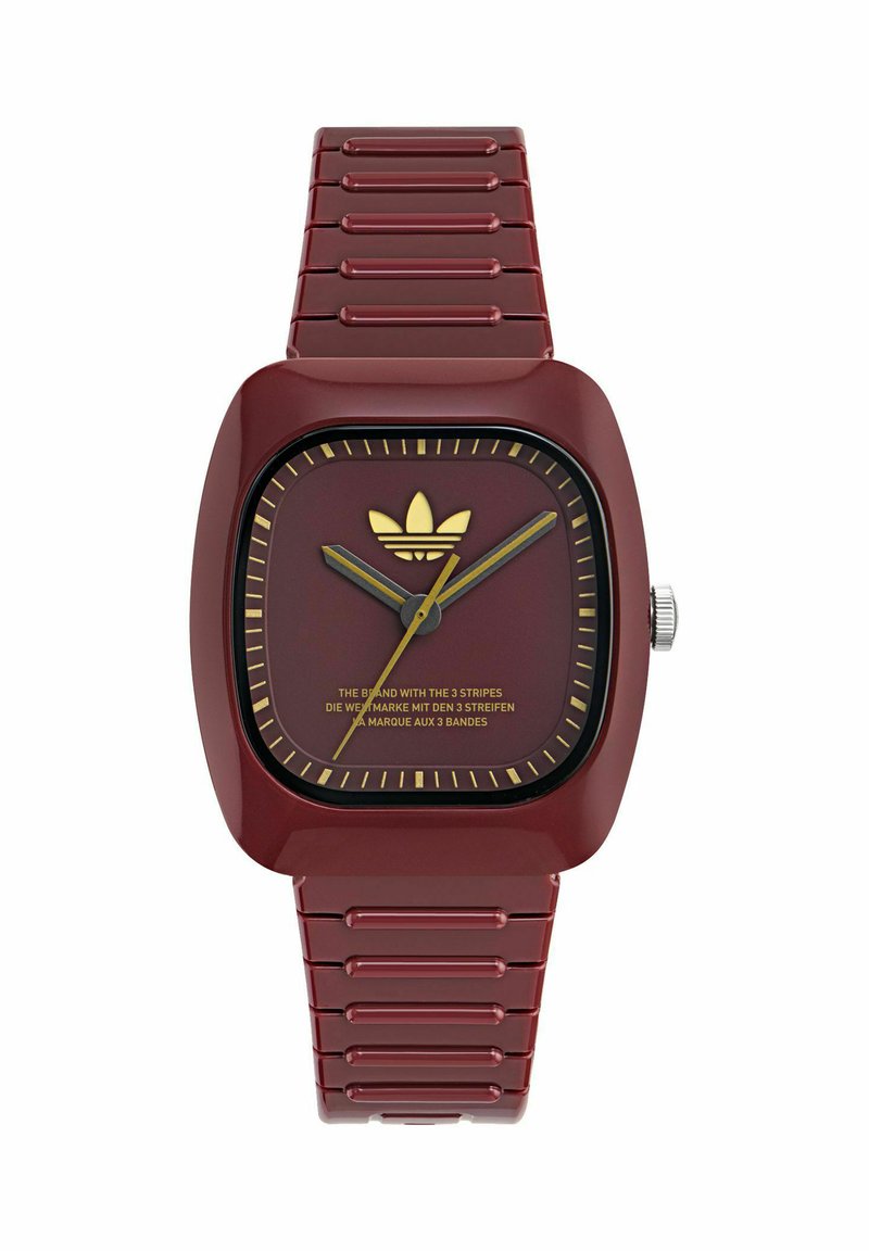 Orologio quadrato rosso con cinturino in plastica liscia, dettagli dorati e quadrante minimalista con logo del marchio e indicatori delle ore.