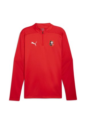 Rød sportspullover med lange ærmer og lynlåsskørt, Puma-logo på højre bryst og Stade Rennais Fodboldklub-badge på venstre bryst.