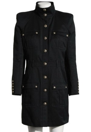 Manteau style militaire noir avec col haut, manches longues, fermeture à boutons sur le devant et plusieurs poches à rabat boutonnées sur la poitrine et les hanches.