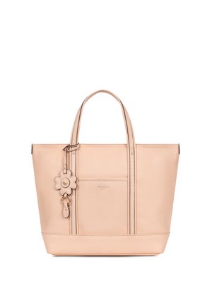 Beige leren tote bag met twee handvaten, een voorvak en een bloemenvormige sleutelhanger bevestigd aan één handvat.