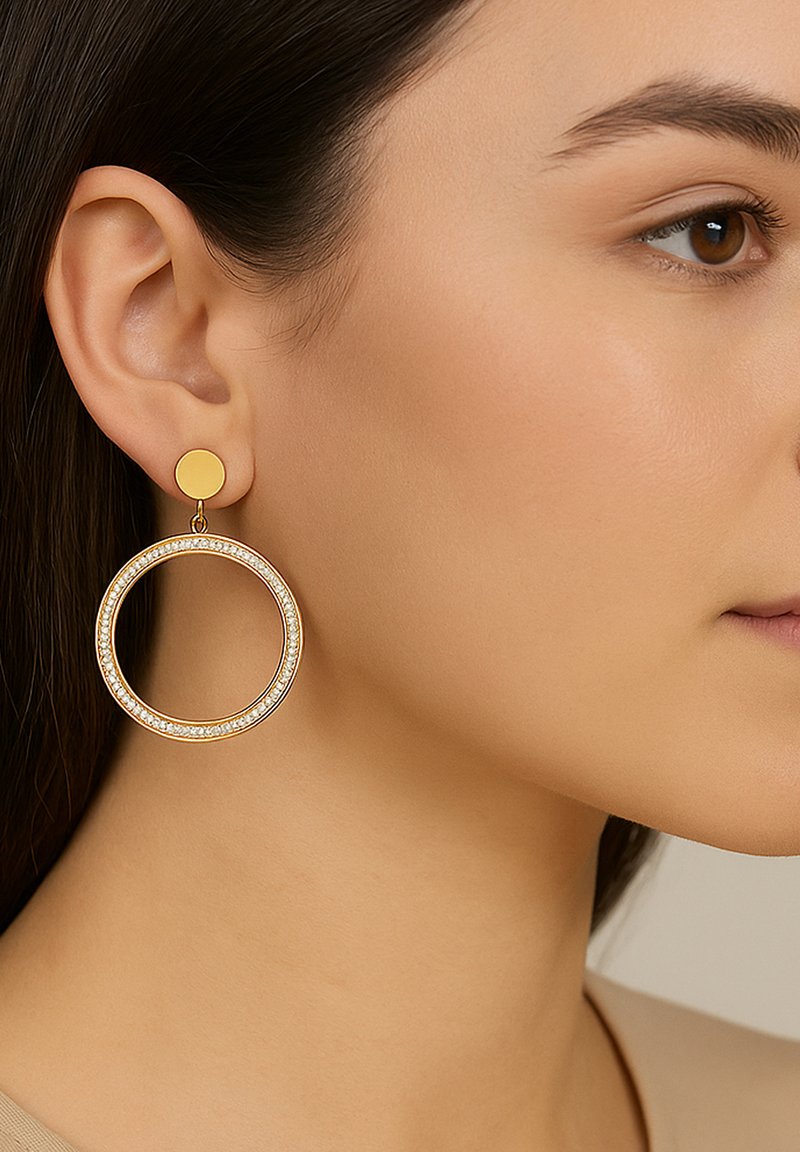 Goldene Creolen mit kreisförmigem Design, featuring einen kleineren runden Stecker und einer strukturierten Kante mit eingearbeiteten Kristallen.