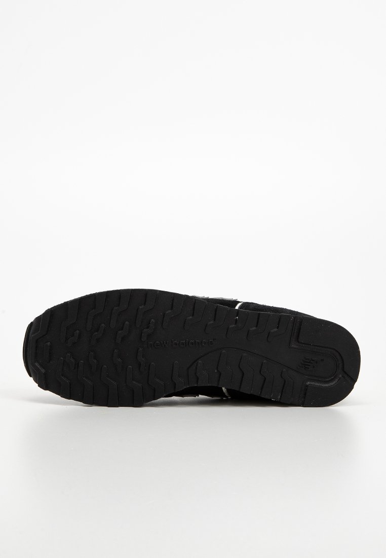 Schwarze Sneaker-Sohle mit einer strukturierten Gummioberfläche und einem Zickzack-Profil sowie detaillierter Markenkennzeichnung an der Seite.
