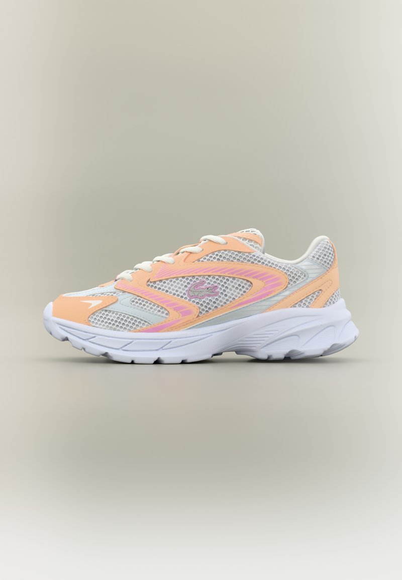 Sneaker atletico bianco e pesca con pannelli in mesh, lacci bianchi, suola spessa bianca e logo di coccodrillo rosa sul lato.