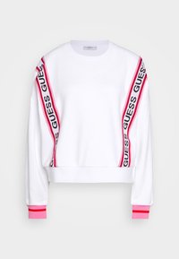 Sudadera blanca de algodón con franjas de marca "GUESS" en rosa y negro en las mangas, puños acanalados y un diseño relajado y corto.