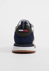 Sneaker blu navy in materiale scamosciato, con dettagli bianchi e oliva, tallone rotondo con una targhetta logo e suola in gomma testurizzata.