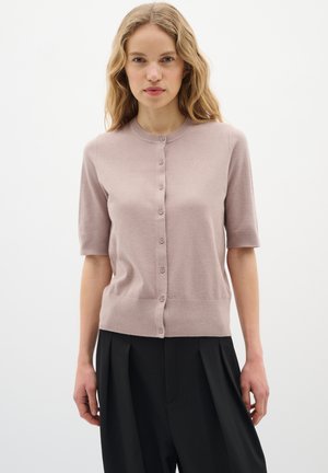 Světle růžový pletený cardigan s krátkými rukávy, kulatým výstřihem a šesti knoflíky. Hladká textura, přiléhavý v pase.