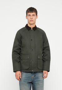 Olijfgroen jack met een corduroy kraag, drukknoopsluiting en twee voorzakken; ontworpen met een iets losse pasvorm en een gestructureerde stof.