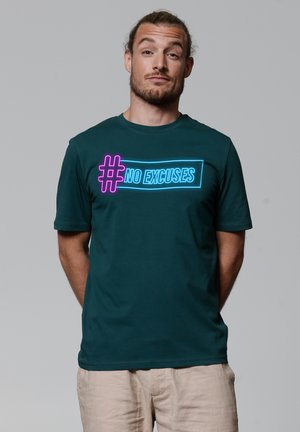 Donkergroene katoenen t-shirt met een neonroze en blauwe grafische print "#NO EXCUSES" op de voorkant. Korte mouwen en een ronde hals.