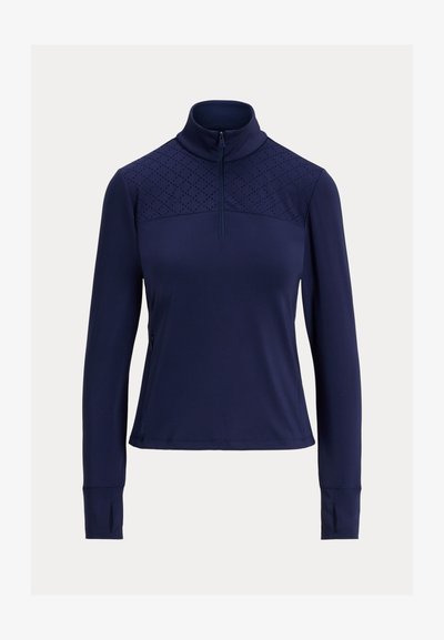 Pullover azul-marinho com fecho de um quarto, mangas longas, com um painel superior texturizado e buracos para os polegares. Feito de um tecido liso e elástico.