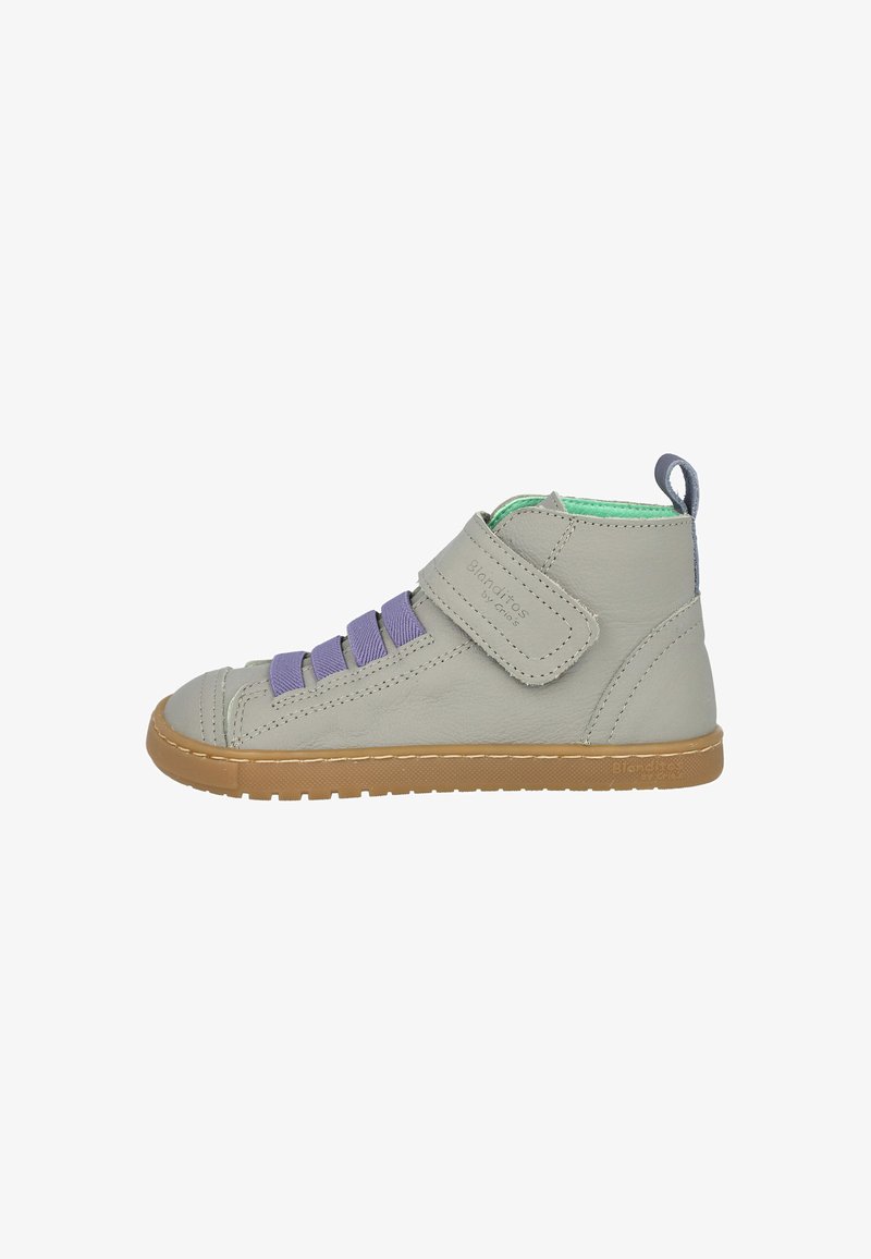 Zapato alto de cuero gris con cordones elásticos morados y una correa de Velcro. Presenta un interior verde y una suela de goma.