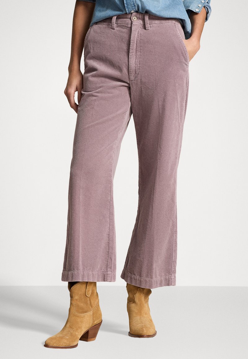 Light pink corduroy wide-leg pants with subtle vertical stripes and a button closure. Accompanied by tan cowboy-style ankle boots.