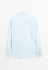 Camicia a maniche lunghe azzurro chiaro con polsini abbottonati, colletto e design posteriore dritto. Realizzata in un tessuto morbido con texture uniforme.