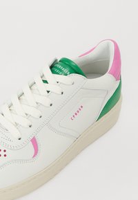 Vita lädersneakers med rosa och gröna accenter, texturerad tunga, platta skosnören och branding i rosa på sidan. Gummisula.