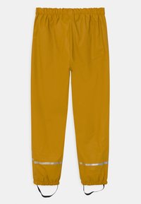 Gele waterdichte regenbroek met een elastische tailleband, reflecterende strepen nabij de enkels en verstelbare bandjes, gemaakt van glad, duurzaam materiaal.