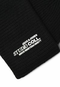 Czarna dzianinowa czapka z prążkowanym wzorem. Posiada białe logo z napisem "JACK & JONES STUDIO COLL. SINCE NINETEEN NINETY." Umieszczone w widocznym miejscu.