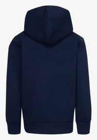 Granatowa bluza z kapturem o miękkiej teksturze, z kieszenią kangurką i ściągaczami przy rękawach. Posiada dopasowany kaptur oraz jednolitą tylną część.