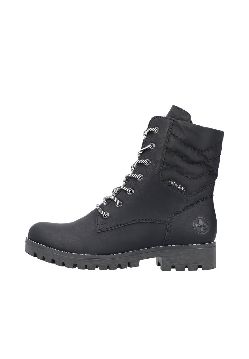 Bottines noires en cuir avec un tige texturée et matelassée, dotées de lacets argentés, d'une semelle robuste, et d'un accent de logo circulaire sur le côté.