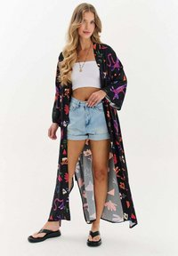 Dlouhý černý kimono s barevnými květinovými a abstraktními vzory, lehký materiál, otevřený vpředu a široké rukávy, doplněný o džíny šortky.