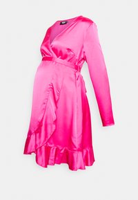 Vestido envolvente de cetim rosa com mangas longas, decote em V, barra com volantes e cinto ajustável. Textura suave e silhueta ajustada projetada para vestuário de maternidade.