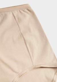 Beige sömlösa hipstertrosor i mjukt material. Har en slät midja, förstärkta sömmar och en minimalistisk design.
