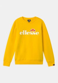 Žlutá mikina z bavlněné směsové látky. Má kulatý výstřih, dlouhé rukávy a logo „ellesse“ v bílé barvě s červeným akcentem.