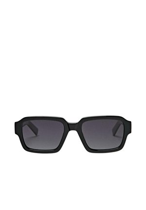 Schwarze rechteckige Sonnenbrille mit dicken Rahmen und dunkel getönten Gläsern vor weißem Hintergrund.