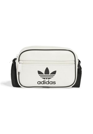 Mała biała torebka na ramię Adidas z czarnym regulowanym paskiem, przednią kieszonką na zamek, czarnym wykończeniem i czarnym logo Adidas trefoil.