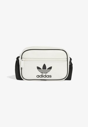 Lille hvid Adidas crossbody taske med sort justerbar rem, lynlåslomme foran, sort kant og sort Adidas trefoil-logo.