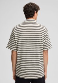Korte mouwen shirt met een crèmekleurige achtergrond, zwarte horizontale strepen, een puntige kraag en een textielgebreide stof.