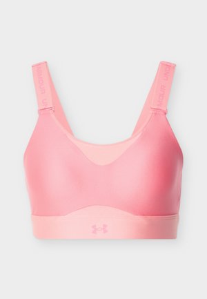 Rausvos spalvos sportinė liemenėlė su reguliuojamomis petnešėlėmis, puošta „Under Armour“ prekės ženklu, lygiu audiniu ir plačia elastinga juosta po krūtine, suteikiančia atramą.