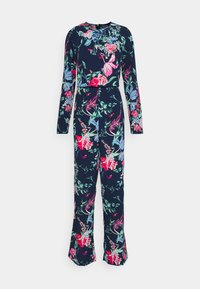 Macacão floral em azul marinho com mangas longas. Apresenta uma mistura de flores vibrantes em rosa, verde e roxo. Cintura ajustada com pernas largas.