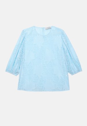 Blusa azzurro chiaro con motivo floreale testurizzato, scollatura rotonda e maniche puff a tre quarti. Realizzata in un tessuto leggero e semitrasparente.