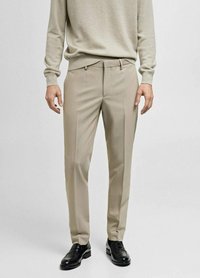 Pantalons beige ajustés à coupe droite, en tissu léger, avec un devant plat, deux poches latérales et des détails de pli.